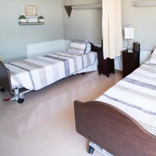 A hospital room with two patient beds and a clean, organized environment.