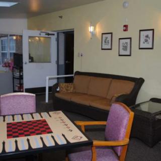 A living room with a couch, chairs, and a table featuring a game board.