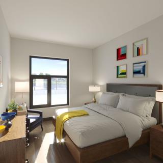 A modern bedroom with a stylish bed, decorative artwork on the wall, and ample natural light from the window.