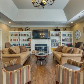 A cozy living room with a fireplace, bookshelves, and comfortable seating.