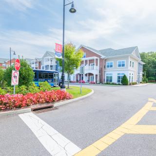 A charming suburban building with a well-maintained garden and clear sky.