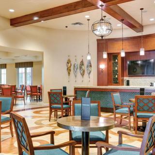 A modern dining area with wooden furniture and decorative lighting.