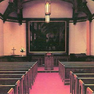 Interior view of a church with rows of pews and a pulpit at the front.