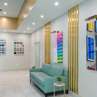 A modern and inviting lobby featuring a turquoise sofa, colorful artwork, and elegant wall accents.