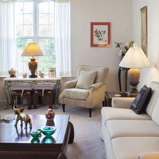 A cozy living room with neutral-toned furniture and warm lighting.