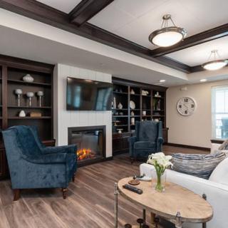 A modern living room featuring a fireplace, built-in shelving, and plush seating.