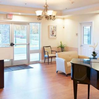A bright lobby area featuring comfortable seating and a grand piano.
