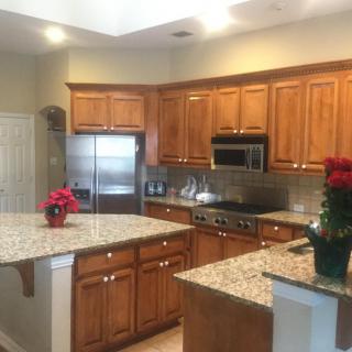 A spacious kitchen featuring granite countertops and wooden cabinets.