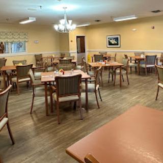A spacious dining area with tables and chairs arranged for communal dining.