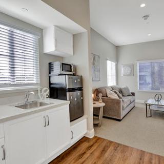 A cozy apartment featuring a modern kitchen and living area, bathed in natural light.