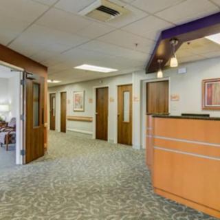 An office reception area with a front desk and multiple doors leading to other rooms.