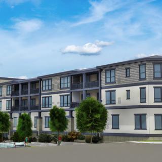 A modern apartment building with a clear blue sky and surrounding trees.