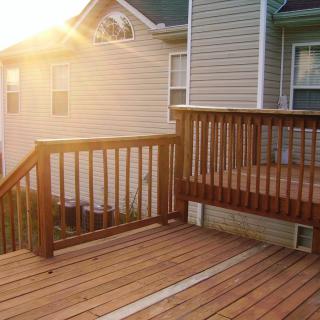 Sunlit wooden deck attached to a house.