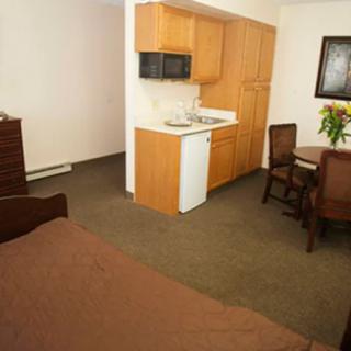 A compact studio apartment featuring a kitchenette and dining area.
