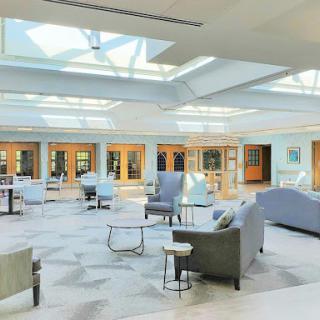 A bright and modern interior lobby featuring comfortable seating and ample natural light from skylights.