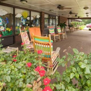 A cozy porch with colorful rocking chairs and vibrant flowers.