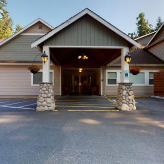 A residential building with a covered entrance and stone pillars.