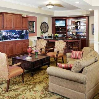 A cozy living room with comfortable seating, a wooden coffee table, an aquarium, and a television.