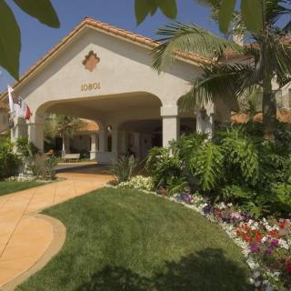 A well-landscaped building entrance with greenery and flowers.