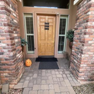A welcoming front door with brick columns and a pumpkin decoration.
