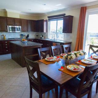 A modern kitchen and dining area with wooden furniture and bright natural lighting.