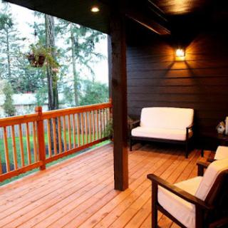 A cozy porch with comfortable seating, surrounded by nature.