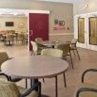 An empty dining room with round tables and chairs arranged neatly.