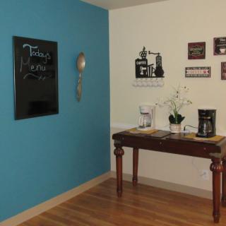 A cozy kitchen corner with a coffee station and decorative wall art.