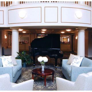 An elegant lobby with a grand piano and comfortable seating area.