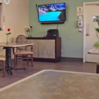 A cozy restaurant interior with tables, chairs, and a television on the wall.