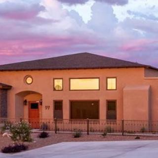 Modern house at sunset with a clear sky and warm lighting.