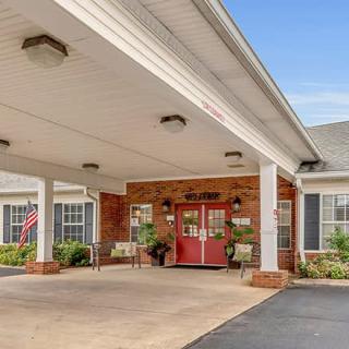 Entrance of a building with a covered canopy and red doors.