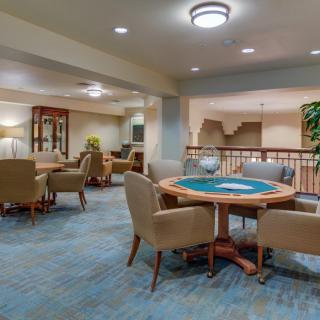 A cozy lounge area featuring a round table with chairs and soft lighting.