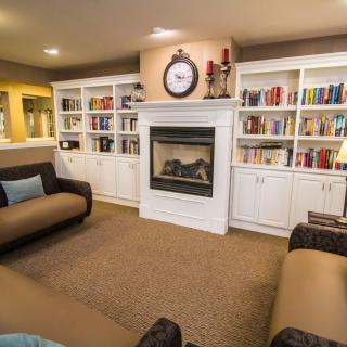 Cozy living room with a fireplace surrounded by bookshelves and comfortable seating.