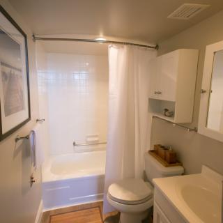 A cozy and compact bathroom with a shower, toilet, and sink.
