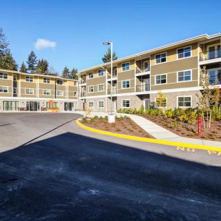 A modern apartment building with a well-maintained exterior and surrounding landscape.