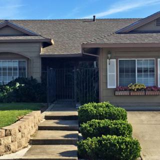 A well-maintained residential house with a stone pathway and neatly trimmed bushes.