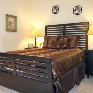Cozy bedroom with a stylish dark wood bed frame and warm lighting.