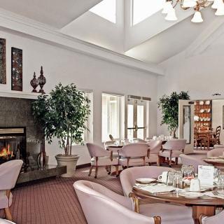 A cozy restaurant interior featuring plush seating, a warm fireplace, and elegant decor.
