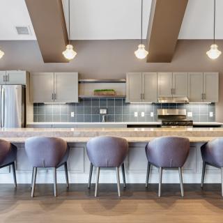 Modern kitchen with bar seating and elegant lighting.