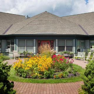 Charming house with a colorful flower garden in front.