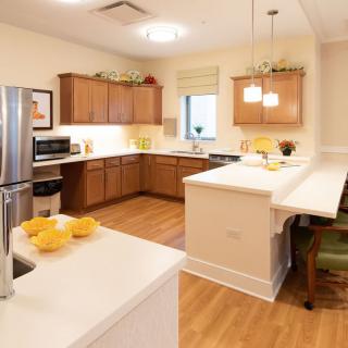 A modern kitchen with wooden cabinets and a cozy island for seating.
