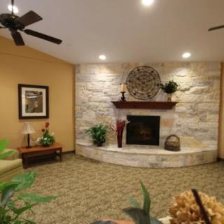 A cozy living room featuring a stone fireplace with decorative accents and comfortable seating.