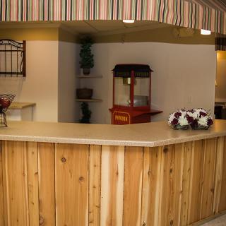 A reception area with a wooden counter and a popcorn machine in the background.