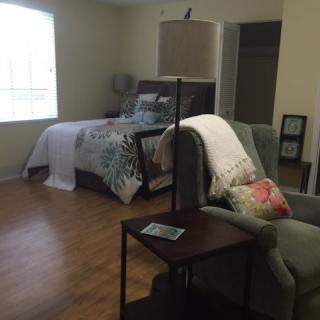 A cozy bedroom with a bed, chair, and stylish decor.
