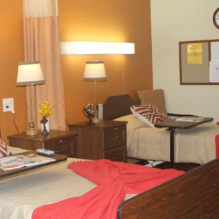 A cozy and well-lit room featuring two beds, stylish furniture, and warm color tones.