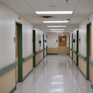 An empty hospital corridor with doors lining both sides.