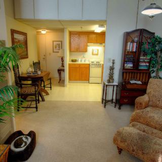 A cozy apartment with a living room leading into a small kitchen and dining area.