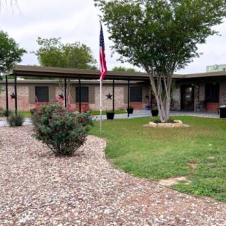 A school building with a flagpole and landscaped grounds.