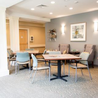 A modern and well-lit seating area with tables and chairs in a contemporary interior space.